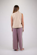 A woman wearing an Atmosea Surf Coach Vest against a white background, posing to the back. 