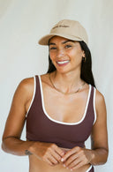 Model wearing the September The Line Barrel Dodger Dad Hat surf-inspired adjustable cap and smiling