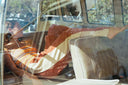 A model in a van wearing the Atmosea Après Surf Panel Pants in rust brown cotton terry with cream side panels, a relaxed wide-leg silhouette, and adjustable drawstring waist.