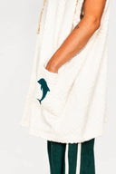 An upclose view of the Atmosea Delfi Après Surf Robe made from plush cotton terry towelling with a zip front, oversized hood, front pockets, and dolphin embroidery.
