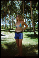 A model outside wearing the Atmosea Ellis Canvas Shorts in three-tone blue cotton with white contrast piping and a high-waisted fit.