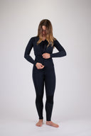 A woman zipping up the Atmosea Luna Wetsuit Front Zip jacket in front of a white background. 