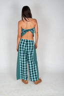 The back view of a model in the Atmosea Patchwork Pants in Turquoise Check featuring a relaxed wide-leg fit and colorful checkered cotton fabric.