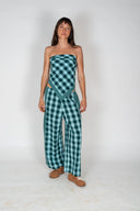 A front view of a model in a studio wearin the Atmosea Patchwork Pants in Turquoise Check featuring a relaxed wide-leg fit and colorful checkered cotton fabric.