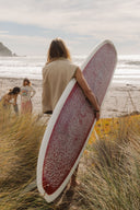 Lifestyle photo of the Atmosea Surf Coach Front Zip Vest with a surfboard.