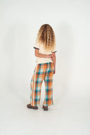 The back view of a model wearing the Atmosea Yaz Artifacts Ringer Tee in sand with dark grey contrast trim and original surf-inspired illustrations by artist Yaz Ward.