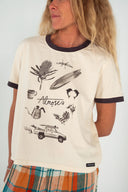 A model wearing the Atmosea Yaz Artifacts Ringer Tee in sand with dark grey contrast trim and original surf-inspired illustrations by artist Yaz Ward.