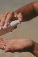 Beachwashed Deep Current Treatment Oil being dispensed onto a hand before application.