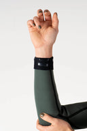 Close-up of the Inner Relm Green Envy Vest 2mm sleeve cuff and flatlock stitching.