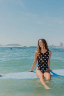 Front view of the Our Ripples Kiki Suit 0.8mm standing in shallow ocean water.