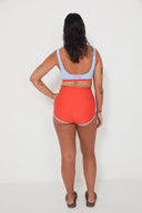 A model wearing the Salt Gypsy Bralette Bikini Top in Baby Blue with Chilli Red trim from the back