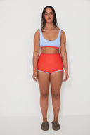 A model wearing the Salt Gypsy Bralette Bikini Top in Baby Blue with Chilli Red trim from the front