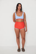 A model wearing the Salt Gypsy Bralette Bikini Top in Baby Blue with Chilli Red trim from the front