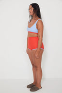 A model wearing the Salt Gypsy Bralette Bikini Top in Baby Blue with Chilli Red trim from the side