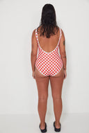 A back view of a model in a studio wearing the Salt Gypsy Everyday One Piece in Chilli Checkers