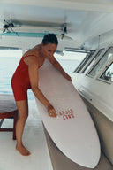 Surfer waxing a surfboard with Salt Gypsy Premium Eco Surf Wax - All Water.