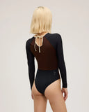 Back view of model wearing Seea Madi Surf Suit in Black/Cappuccino