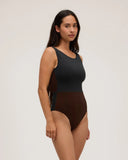 Side view of a model wearing the Seea Pacific One Piece swimsuit in Black/Cappuccino featuring a high neckline, deep V-back, and cheeky coverage.