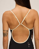 An up close view of the straps on the Seea Rosita One Piece swimsuit in Black featuring white contrast trim, adjustable straps, and a low scoop back.