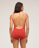 A model wearing the Seea Rosita One Piece women's surf suit in Cinnamon and posing to the back against a white background