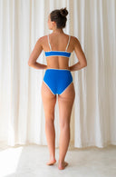 Back view of model wearing the model wearing Island Bikini Bottom in Nineties Blue in a studio