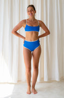 Front view of model wearing the model wearing Island Bikini Bottom in Nineties Blue in a studio