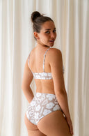 Up close back view of model wearing Lucky Bikini Bottom in Aloha Dune Print in a studio