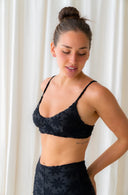 An upclose view of a model wearing the September Maya Bikini Top in Midnight Black Terry