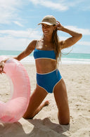 Model wearing River Nineties Blue Bikini Top on the beach