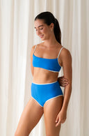 Front view of model wearing River Nineties Blue Bikini Top
