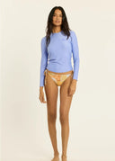 A model wearing the Sisstr Seeker Solid women’s surf rashguard in Blissful Blue