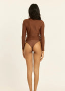 Back view of a model wearing the Sisstr Seeker Solid women’s surf rashguard in Kona brown