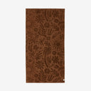 Slowtide Sunny Sculpted Towel with a raised floral pattern in warm brown.