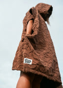 Side view of the Sunward Bound Hooded Changing Towel in Cacao highlighting the oversized fit, hood, and soft organic cotton towelling.