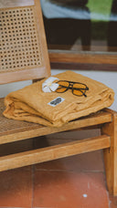Close-up of the Sunward Bound Hooded Changing Towel in Turmeric highlighting the organic cotton towelling fabric.