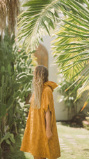 Side view of the Sunward Bound Hooded Changing Towel in Turmeric showing the oversized fit and hood.